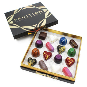 Black confection box containing 16 chocolate confections of various shapes and colors - Fruition Chocolate