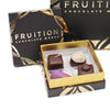 Black confection box containing 4 chocolate confections of various shapes and colors - Fruition Chocolate