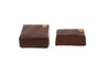 Two chocolate squares with bronze dot on the upper right corner. Manhattan rye flavor