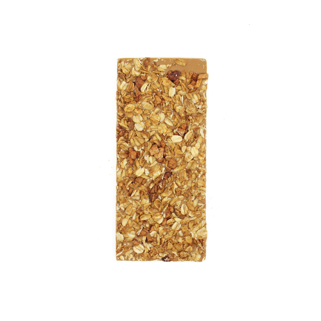 a vertical, light brown white chocolate bar covered in toasted granola and little chunks of spiced dried apple